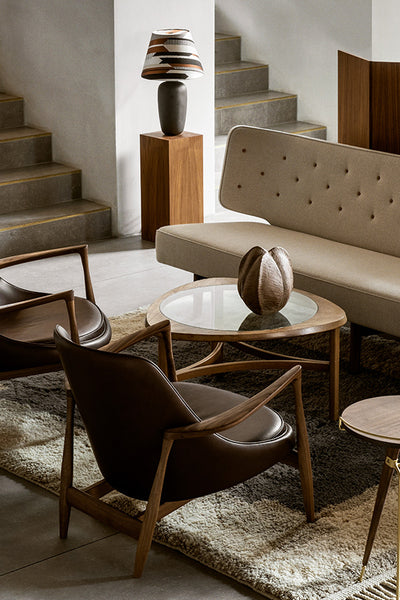 collection picture for two modern chairs flanking a small round green lacquer table with a a black sculpture on top. the wall behind the furniture has a window and is painted a greige color with a textured wood art piece hanging on it.  82